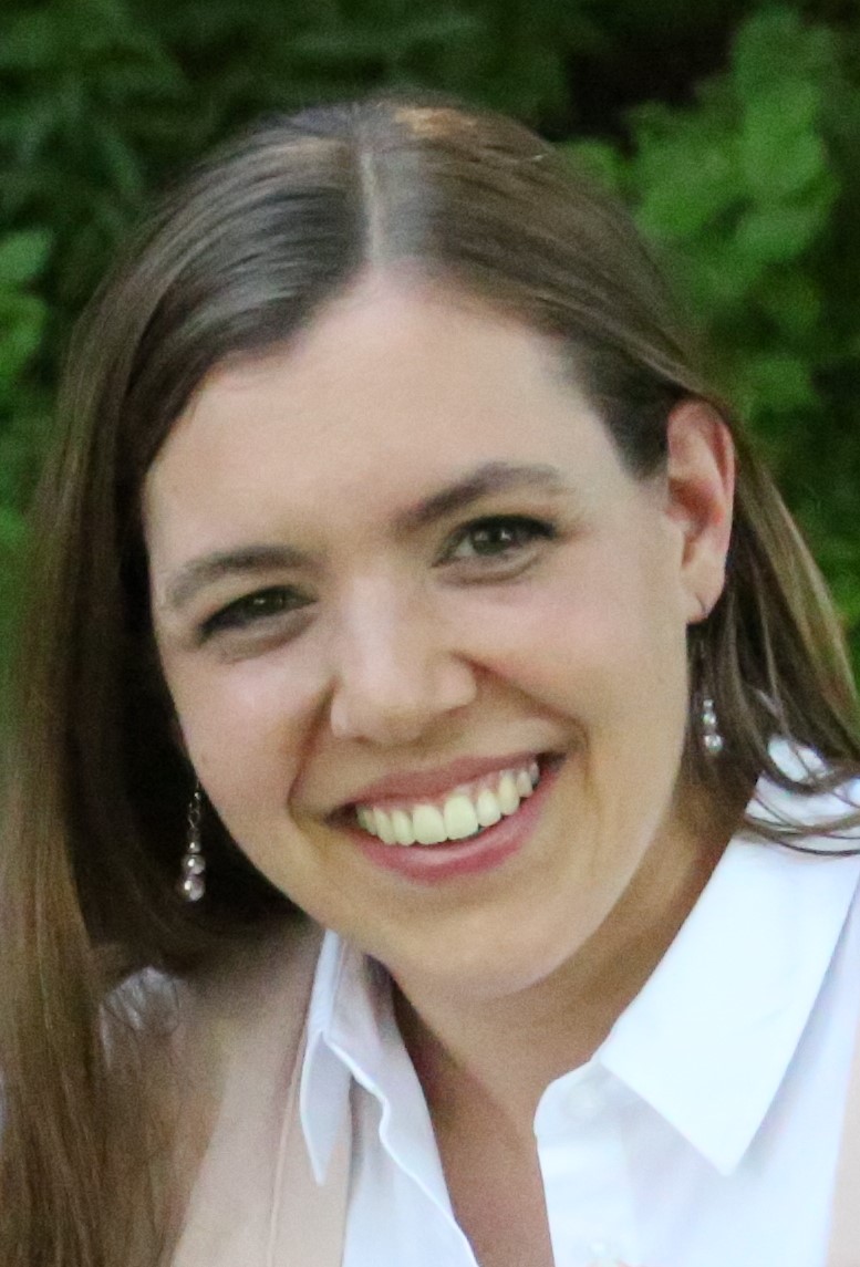 Photo of Emily Keebler, a woman with brown hair, silver earrings, and a white-collared shirt.